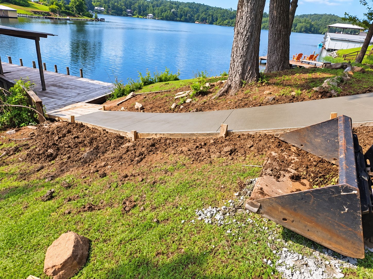 New concrete walkway running along a lakefront yard